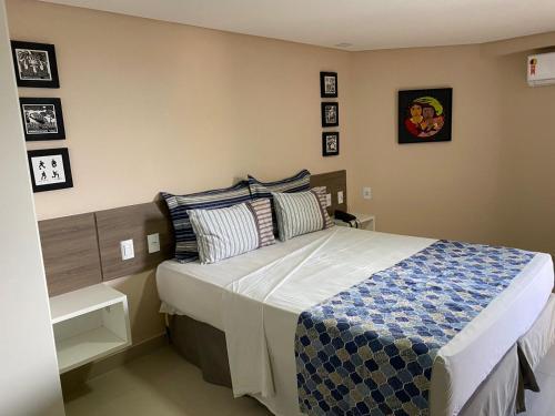 1 dormitorio con 1 cama con manta azul y blanca en Gold Flat Cabo Branco, en João Pessoa