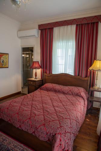 a bedroom with a large bed with a red comforter at Archontiko Stamou in Zagora