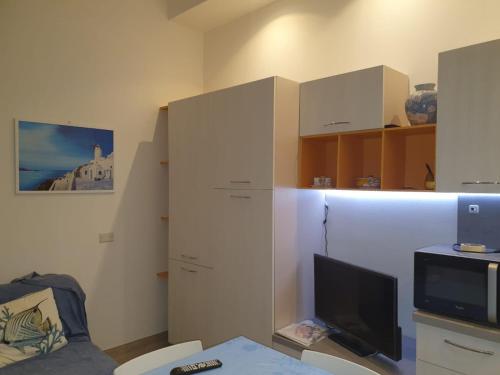 a room with a desk with a computer and a tv at Sea House in Marzamemi