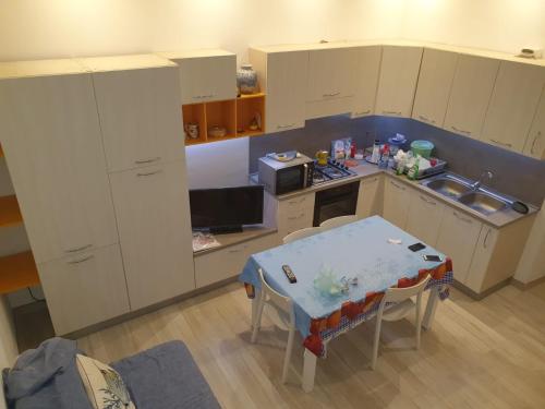 a small kitchen with a table and a small kitchen with white cabinets at Sea House in Marzamemi