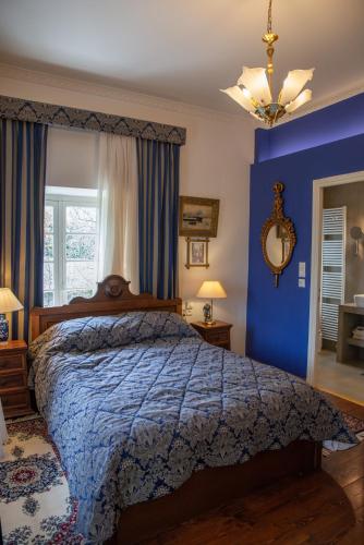 a bedroom with a bed with a blue wall at Archontiko Stamou in Zagora