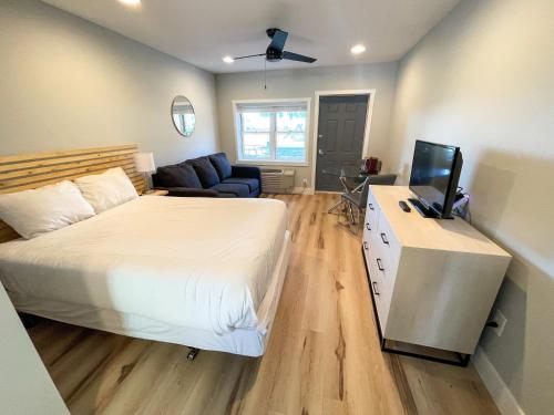 a bedroom with a bed and a television and a couch at Lake Bluff Inn and Suites in South Haven