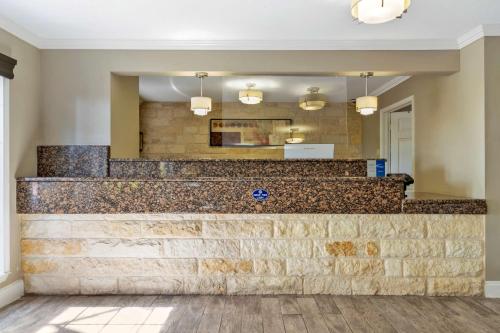 a lobby with a stone wall and a counter at Best Western Brady Inn in Brady