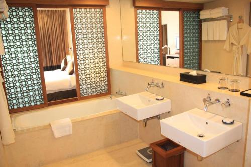 a bathroom with two sinks and a large mirror at Radisson Blu Dhaka Water Garden in Dhaka