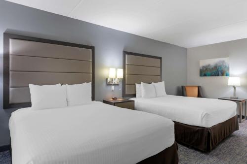 two beds in a hotel room with white sheets at Best Western Plus McAllen Airport Hotel in McAllen