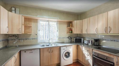 a kitchen with a sink and a washing machine at Casa Rural Liviana, Piscina Barbacoa y preciosas vistas Málaga by AndaraHolidays in Cómpeta