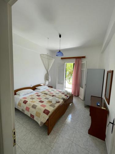 um quarto com uma cama e uma janela em NAFSIKA Apartments em Agios Georgios Pagon
