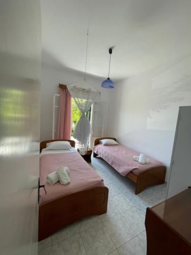 - une chambre avec 2 lits et une fenêtre dans l'établissement NAFSIKA Apartments, à Agios Georgios Pagon
