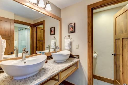 Un baño con dos lavabos y un espejo grande. en Peak 9 Studio of Dreams, en Breckenridge