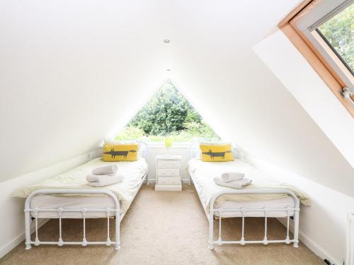 two beds in a attic room with a christmas tree at Oak Tree Lodge in Rackheath