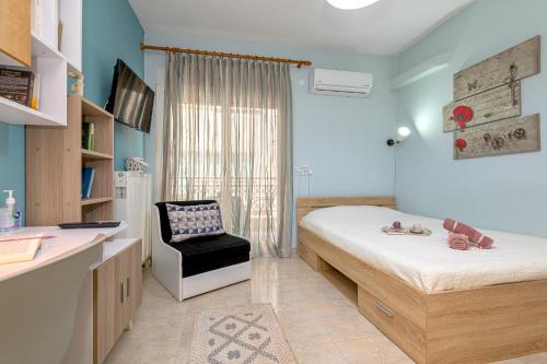 Melody Apartment في Néa Khilí: غرفة نوم فيها سرير وكرسي