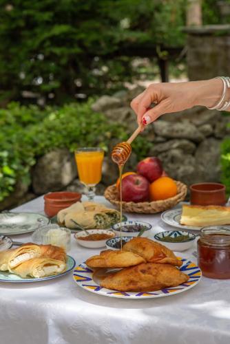 a person holding a spoon with food on a table at Archontiko Stamou in Zagora
