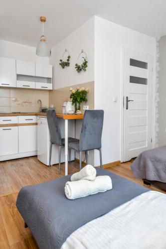 a bedroom with a bed and a table with chairs at Apartamenty Majka in Zator