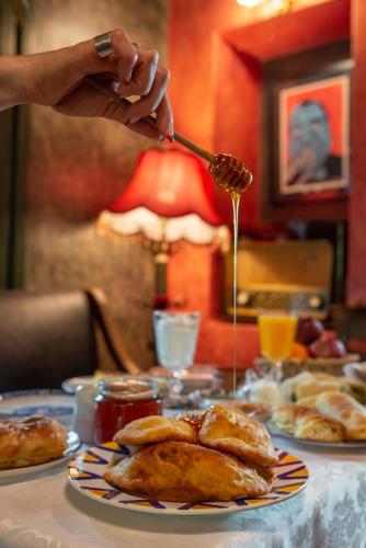 a person pouring honey onto a plate of food at Archontiko Stamou in Zagora