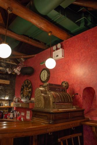 a bar with a clock on a red wall at Archontiko Stamou in Zagora