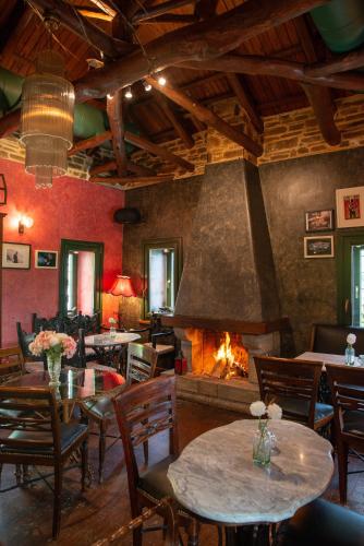 a restaurant with tables and a fireplace at Archontiko Stamou in Zagora