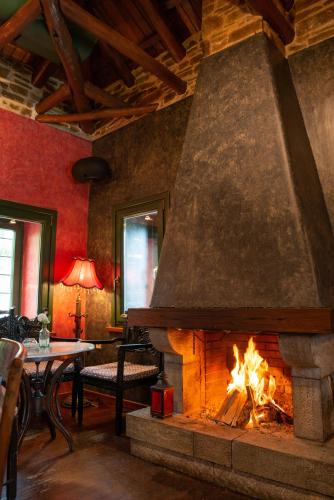 a fireplace in a living room with a fire at Archontiko Stamou in Zagora