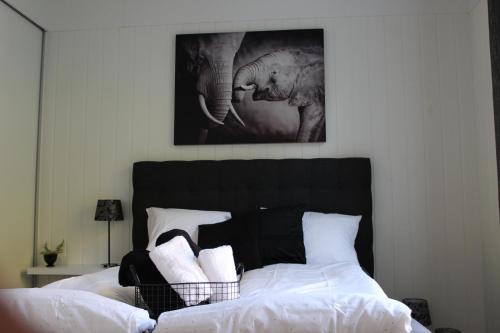 a bedroom with a bed with white sheets and two elephants at Light Sentral Apartment Ålesund in Ålesund