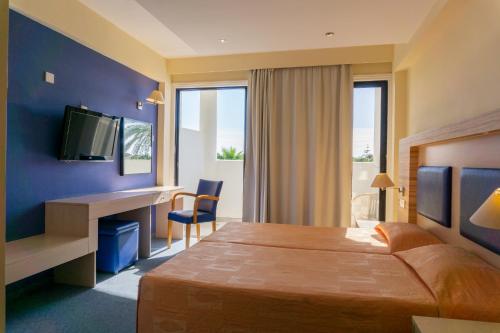 a hotel room with a bed and a desk and a television at Mariandy Hotel in Larnaca