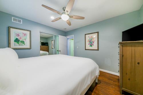 a bedroom with a white bed and a ceiling fan at The Salty Dog in Newport Beach