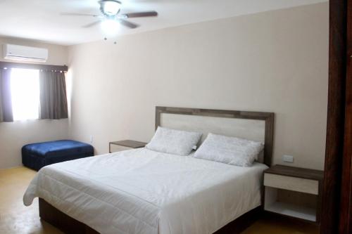 1 dormitorio con cama blanca y ventilador de techo en Hotel Casa Hidalgo, en Torreón