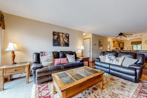 a living room with two leather couches and a coffee table at White Mountain Retreat in Lincoln
