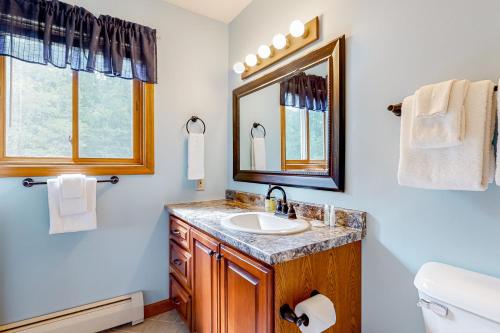 ein Bad mit einem Waschbecken und einem Spiegel in der Unterkunft White Mountain Retreat in Lincoln