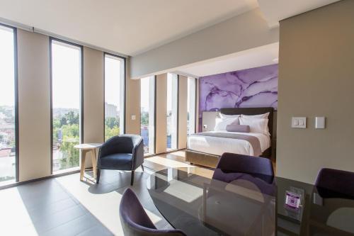 sypialnia z łóżkiem oraz krzesłami i oknami w obiekcie HS HOTSSON Long Stay CDMX Condesa Sur w mieście Meksyk