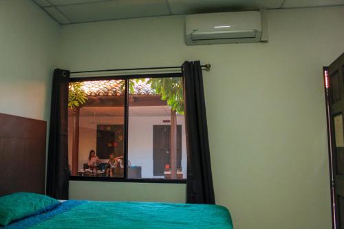 a mirror in a room with a bed and a woman at Casa Hotel Santa Lucia in Suchitoto