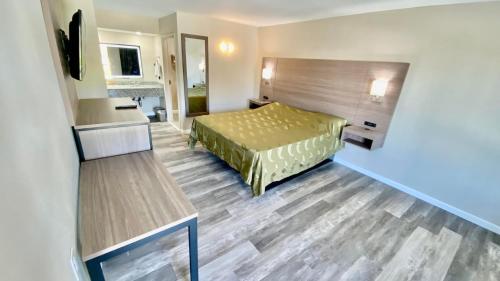a hotel room with a bed and a desk at Brentwood Inn & Suites in Suffolk