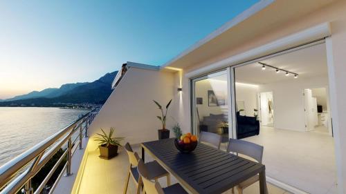 a dining table on the balcony of a boat at Luxury Penthouse Adriatic Blue - On the beach in Tučepi