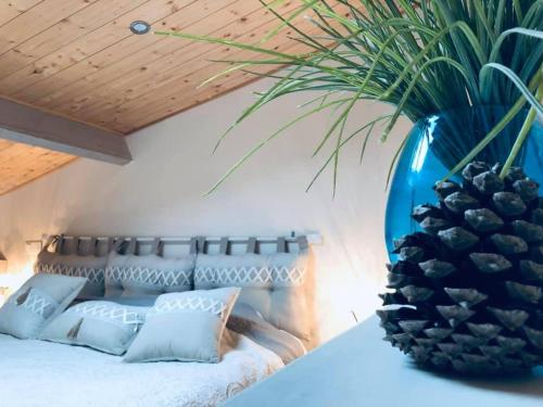 - une chambre dotée d'un lit avec un vase bleu et un ananas dans l'établissement Le Chai de l'Océan -Maison plage à 300m - Jardin Terrasse, à Soulac-sur-Mer