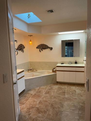 een badkamer met een bad en een wastafel bij Private Heated Pool and Healing Waters Nearby in North Port