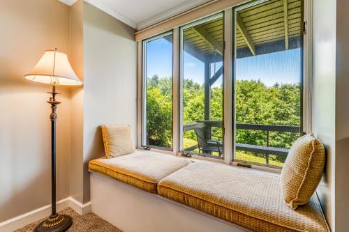 een stoel bij het raam in een kamer met uitzicht op de bomen bij Skyleaf Retreat in Sugar Mountain