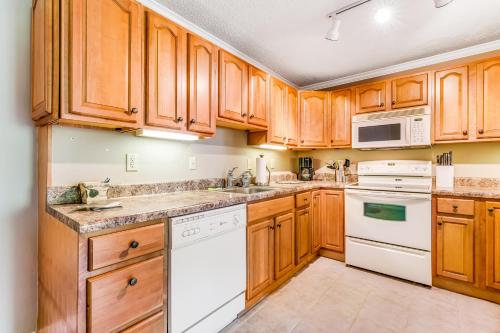 a kitchen with wooden cabinets and white appliances at Skyleaf Retreat in Sugar Mountain