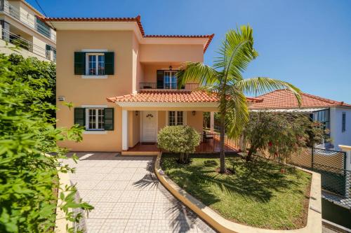 a house with a palm tree in front of it at Vila Boa Vista by An Island Apart in Funchal
