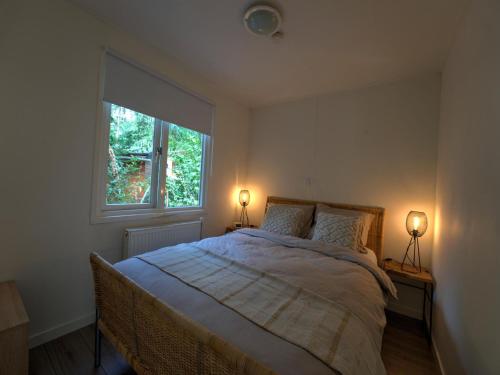 a bedroom with a large bed with two lamps on it at Cosy holiday home in Hattemerbroek with garden in Hattemerbroek