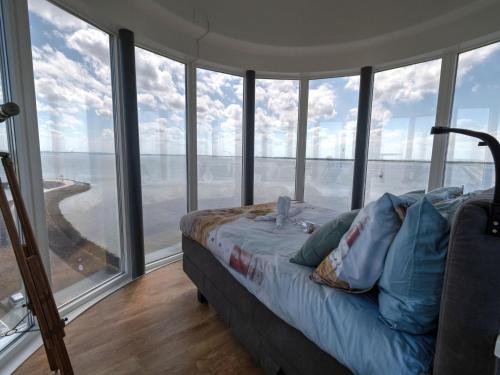 a bedroom with a bed in a room with windows at Premium apartment in Scherpenisse with roofed terrace in Scherpenisse