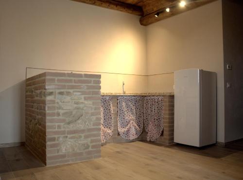 a room with a brick wall and a refrigerator at Agriturismo Fonte Belvedere in Collesalvetti