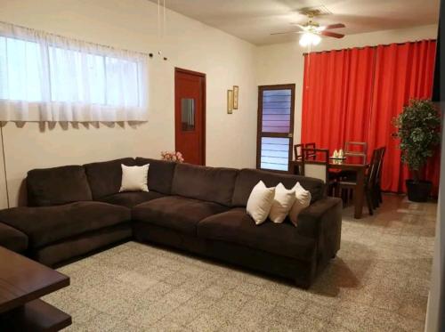un soggiorno con divano marrone e tavolo di Cómodo departamento a Papantla de Olarte