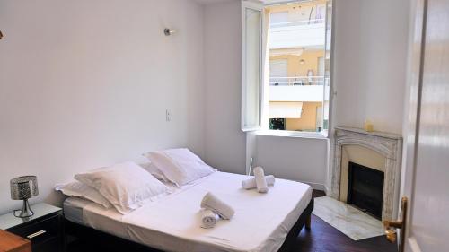 - une chambre avec un lit, une cheminée et une fenêtre dans l'établissement Appartement 1 chambre avec Terrasse, Rue Pons, By Palmazur Vacances, à Cannes