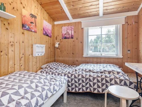 ブラーバンドにあるThree-Bedroom Holiday home in Blåvand 3のベッド2台 木製の壁の部屋
