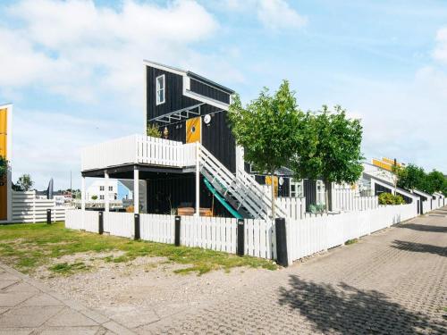 een zwart huis met een wit hek bij 7 person holiday home on a holiday park in Ebeltoft in Ebeltoft