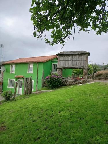 a green house with a building in a yard at Casa en CEDEIRA in Cedeira