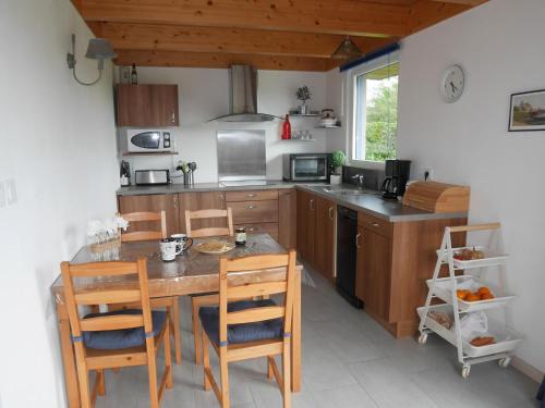 Il comprend une cuisine avec une table et des chaises en bois. dans l'établissement Wooden House in Brittany near Sandy Beach, à Landéda
