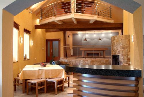 a dining room with a table and a kitchen at Penzion u Pejtrika in Mengusovce