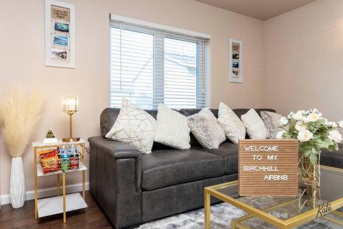 a living room with a black couch and a window at BirchHill retreat Getaway Great Location ! in Fairbanks