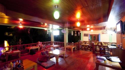 a large room with tables and chairs in a building at J.B.Hut Bungalows in Haad Yao