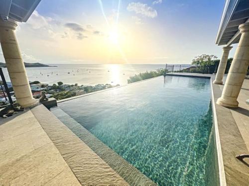 a swimming pool with a view of the ocean at Blue Room in a shared Villa Diamant with communal pool and sea view in Grand Case