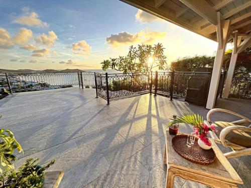 patio con mesa y sillas en el balcón en Frangipani Room in shared Villa Diamant, swimming pool, sea view en Grand Case
